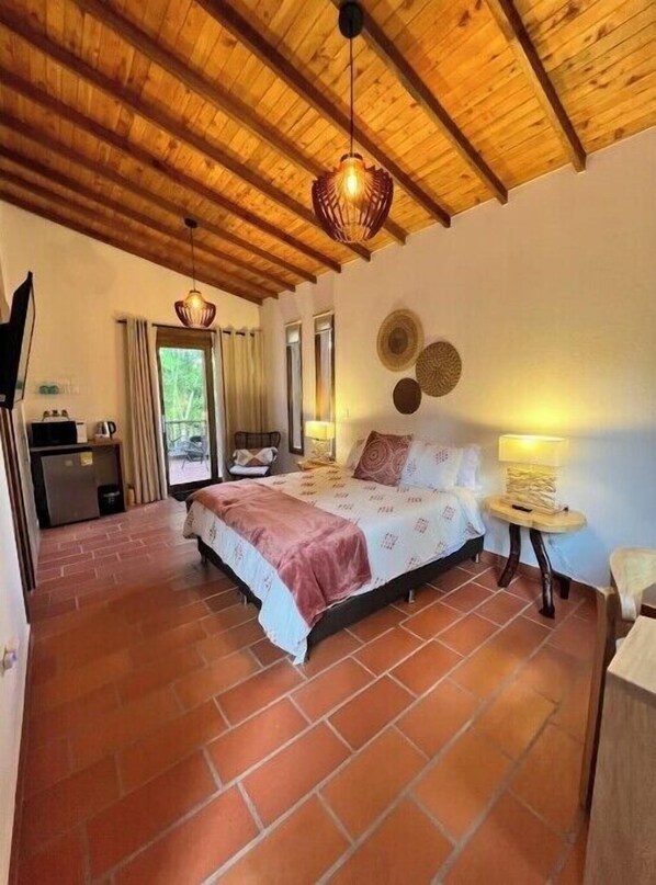 A bedroom with a wooden ceiling, a bed with a pink and white bedspread, two bedside lamps, and a window with curtains. - CASA EVE HOTEL Luxury suite w/ jacuzzi 
breakfast included (la chapa)