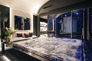 A modern spa room with a hot tub, a sofa, and a large mirror. - Bra Hotel Bari (Bari)