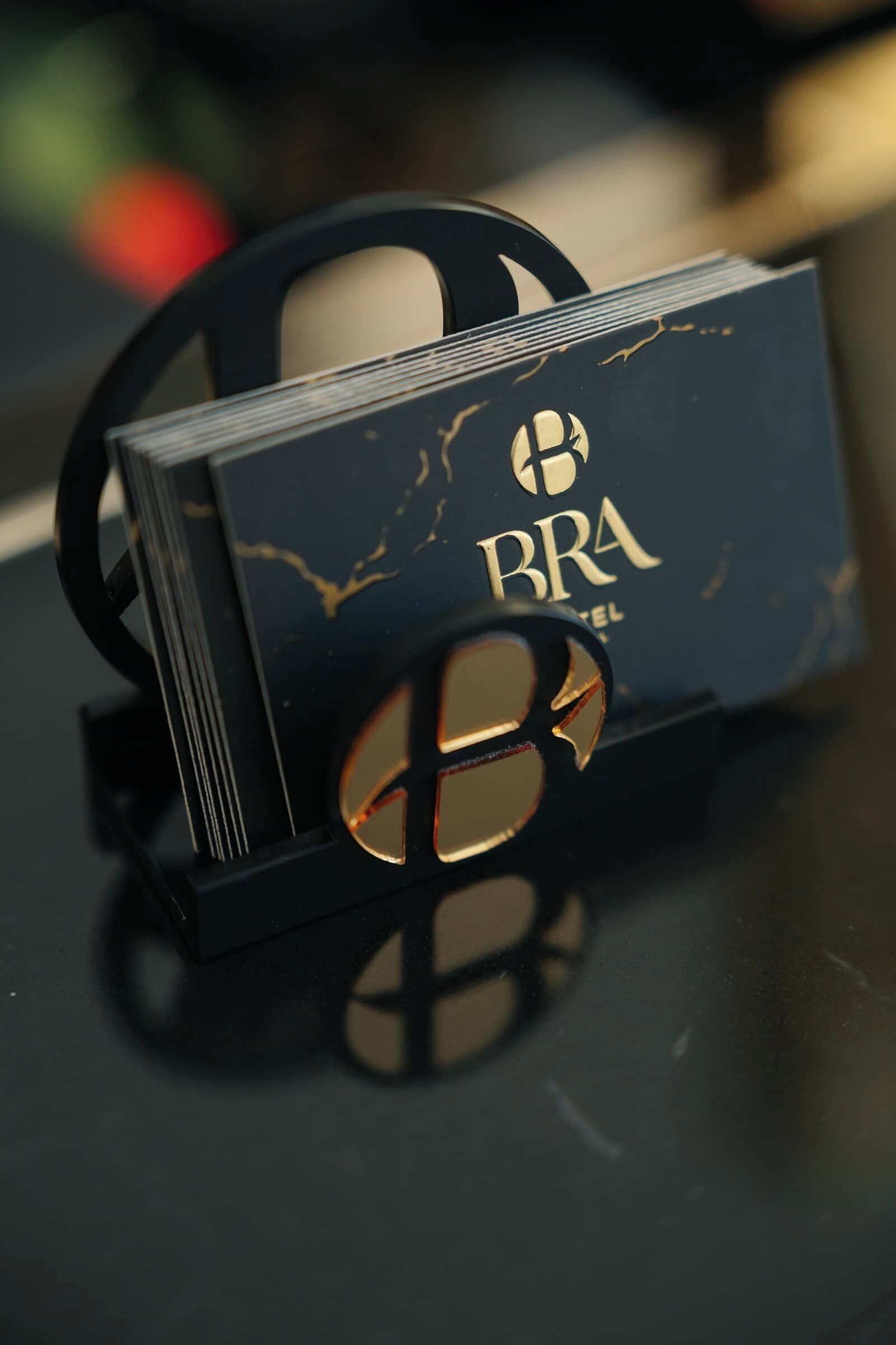 Eine gestapelte Sammlung schwarzer Bücher mit goldener Schrift und einem runden Emblem, auf einer spiegelnden Oberfläche platziert.