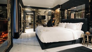 A modern hotel room with a large bed, a TV, and a dining area visible through an open door. - Bra Hotel Bari (Bari)