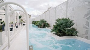 A pool area with white walls, a clear blue pool, and potted plants. - Bra Hotel Bari (Bari)