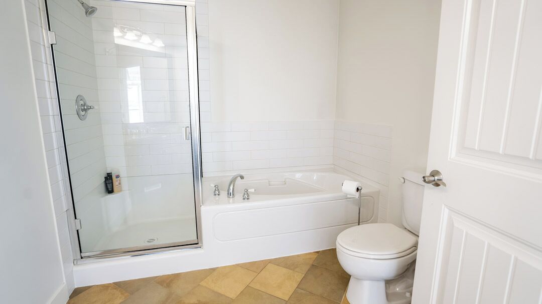Une salle de bain avec une douche à parois de verre, une baignoire et des toilettes.