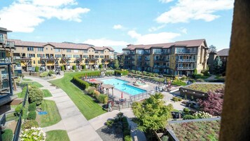 Complejo residencial con piscina central, varios balcones y jardines bien cuidados.