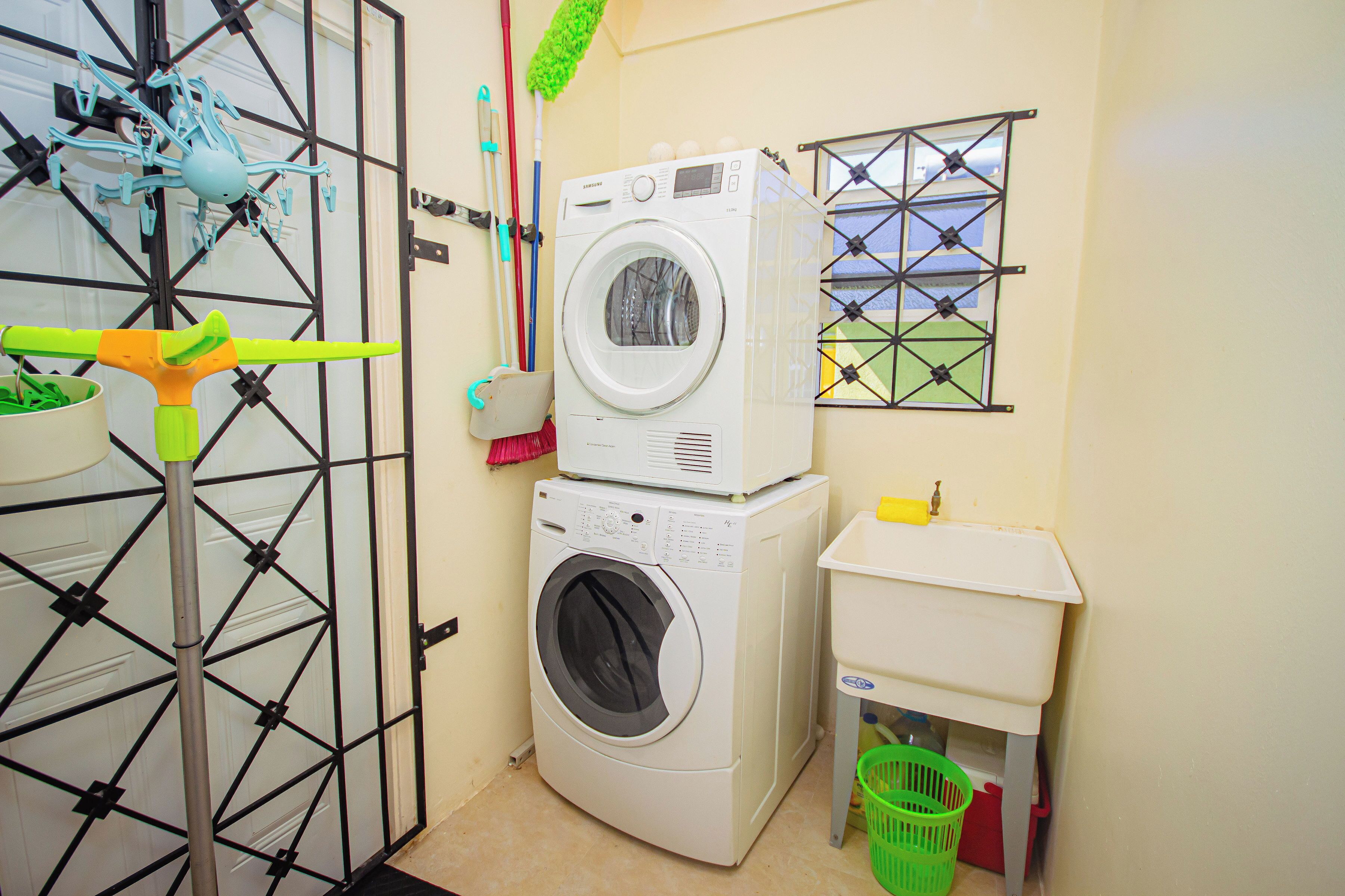 A laundry area with a washing machine, a dryer, and a small sink.
