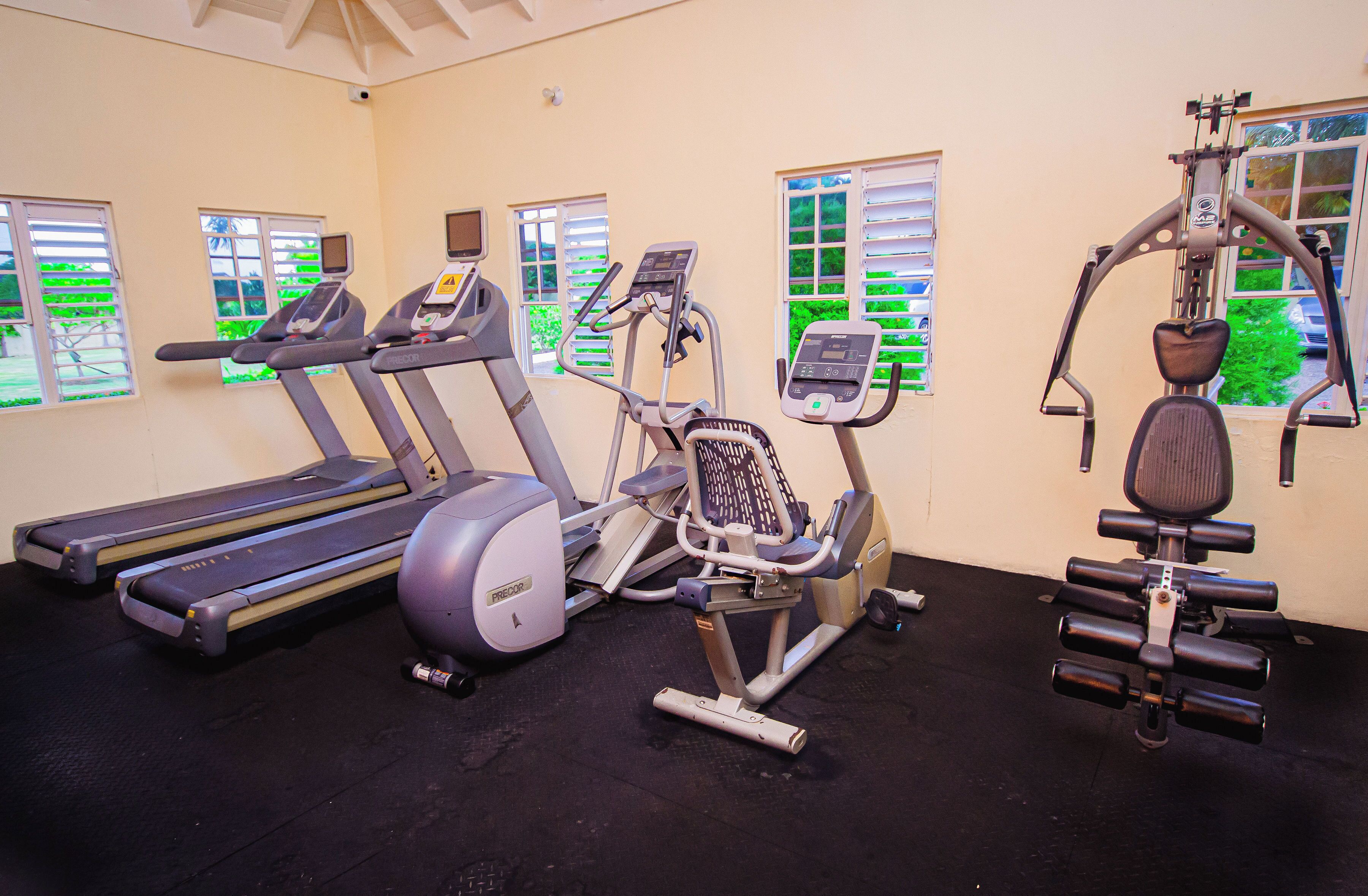 A gym with treadmills, an elliptical, and a multi-functional exercise machine.