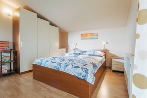 A bedroom with a bed, a nightstand, a dresser, and a bookshelf.