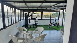 A covered outdoor area with exercise equipment, wicker chairs, and a small table. - Peaceful and beautiful space to spend quality time
close to beach  (Flic en Flac)