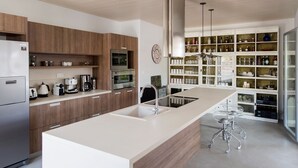 A modern kitchen with a central island, built-in appliances, and a variety of storage cabinets.