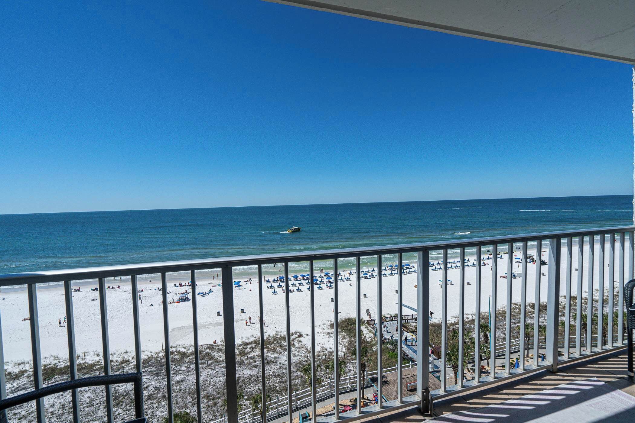 A balcony with a view of a beach and ocean.