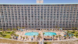 A large hotel with multiple floors, a central swimming pool, and a smaller pool on the ground level. - Mariners Retreat High Rise Beach Living in Pcb! (Panama City Beach)