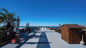 A wooden boardwalk leading to a beach with a clear blue sky. - Mariners Retreat High Rise Beach Living in Pcb! (Panama City Beach)