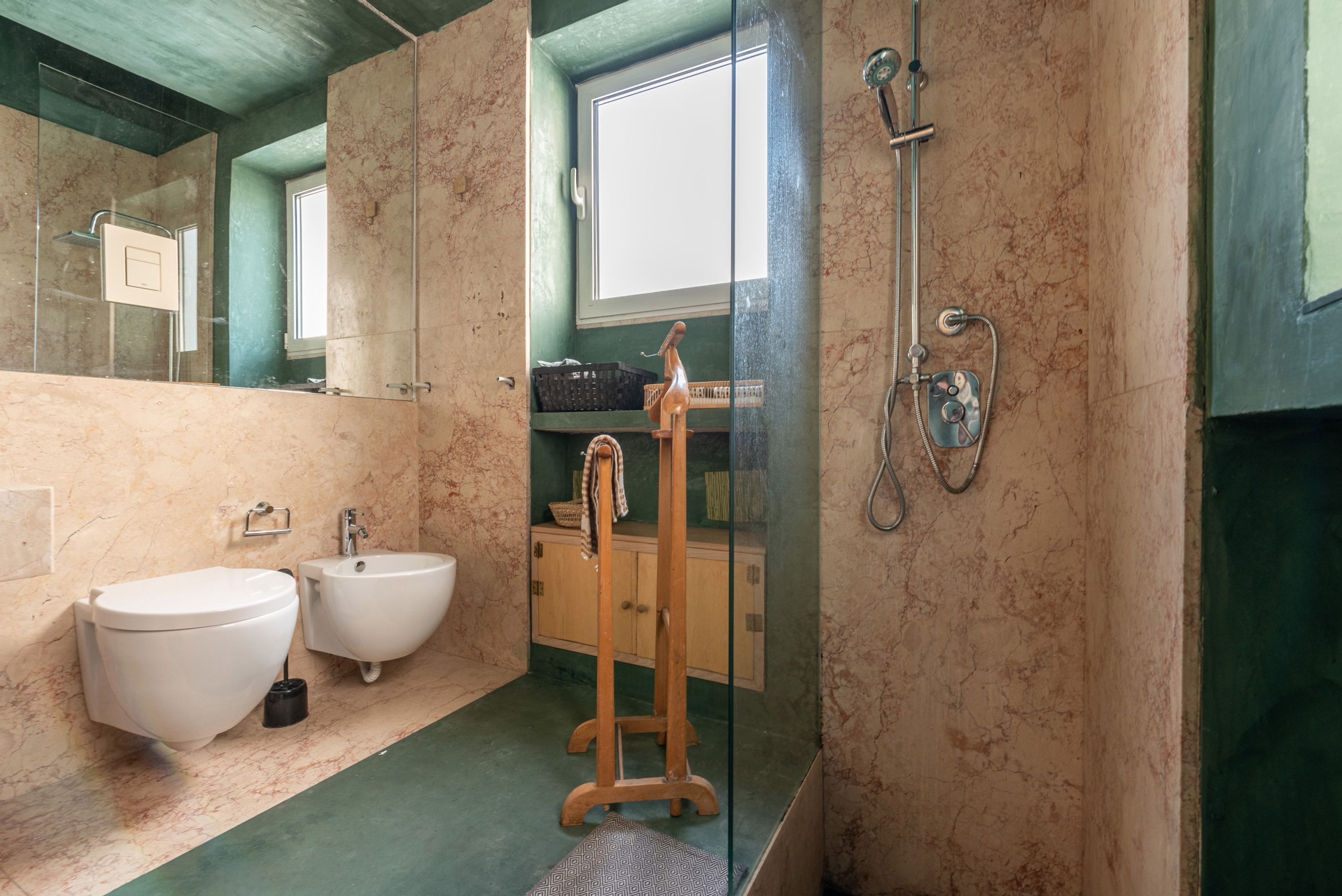 Ein Badezimmer mit Marmorboden, einer Holz-Dusche, einem Waschbecken und einem Bidet.