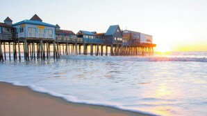 A coastal pier with multiple wooden structures, likely accommodations, extending into the sea. - Latitude Adjustment Walk to Beach & Dining! (Scarborough)
