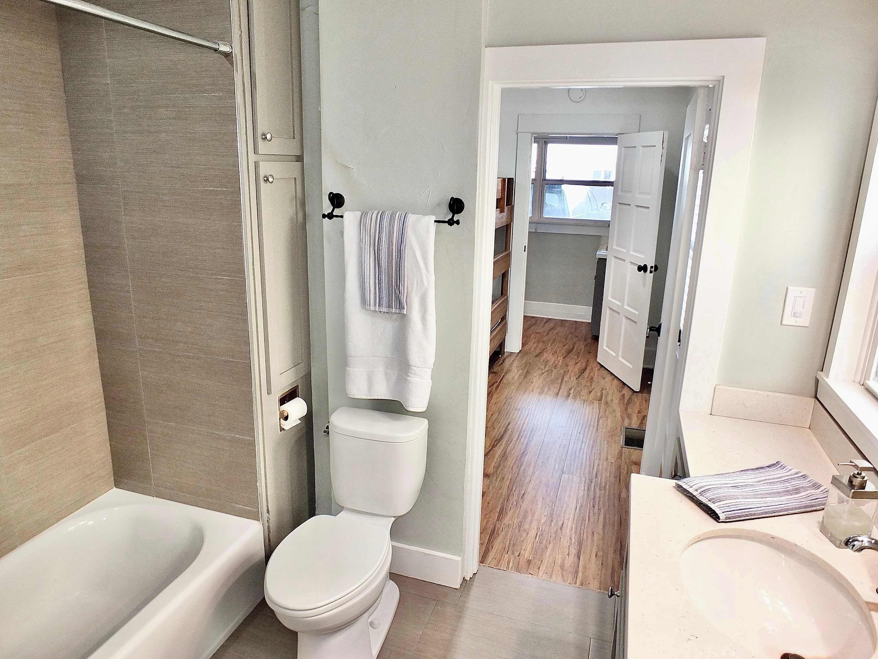 A modern bathroom with a bathtub, toilet, and sink.