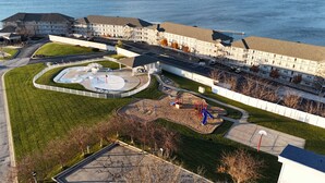 Un hotel grande con varias edificaciones, estacionamiento y un área de juegos.