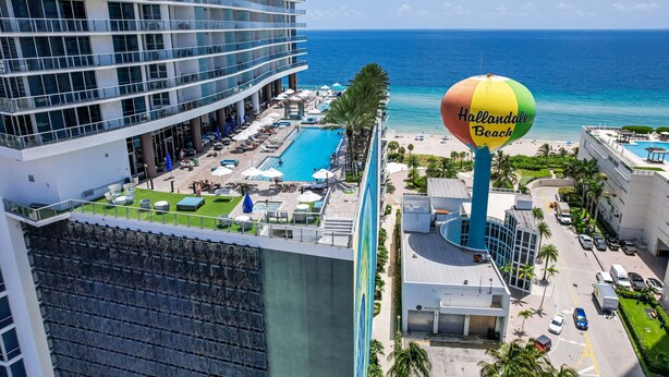 A high-rise hotel with a swimming pool, beach view, and a colorful beach ball sign. - Luxury Penthouse! 4 BDR With Resort Amenities (Hollywood)