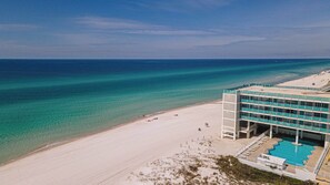 Un hotel frente a la playa con piscina, acceso directo a la costa y aguas azules cristalinas.