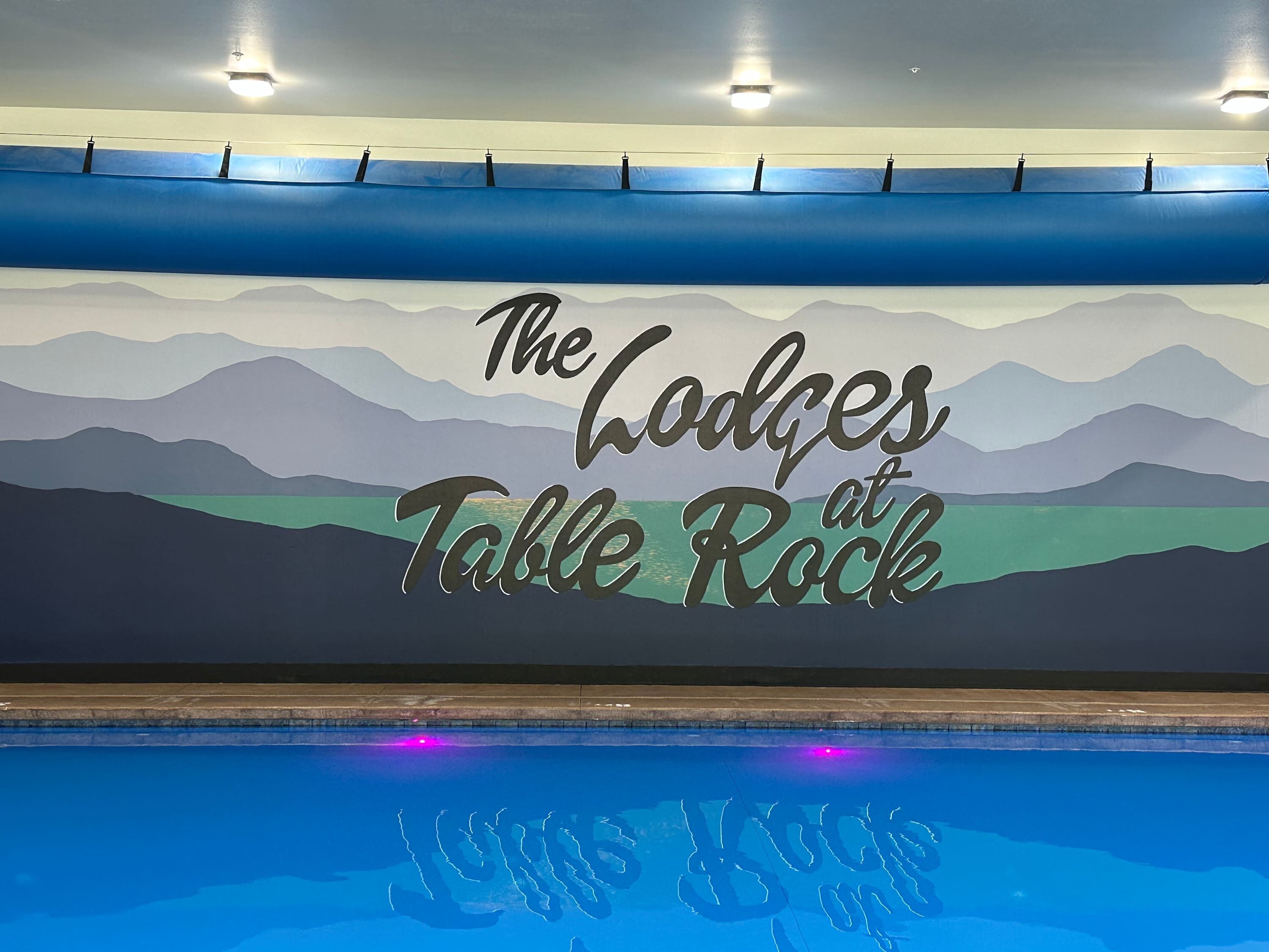 A wall with the text "The Lodges at Table Rock" and a pool with "Lodges at Table Rock" written on the water.