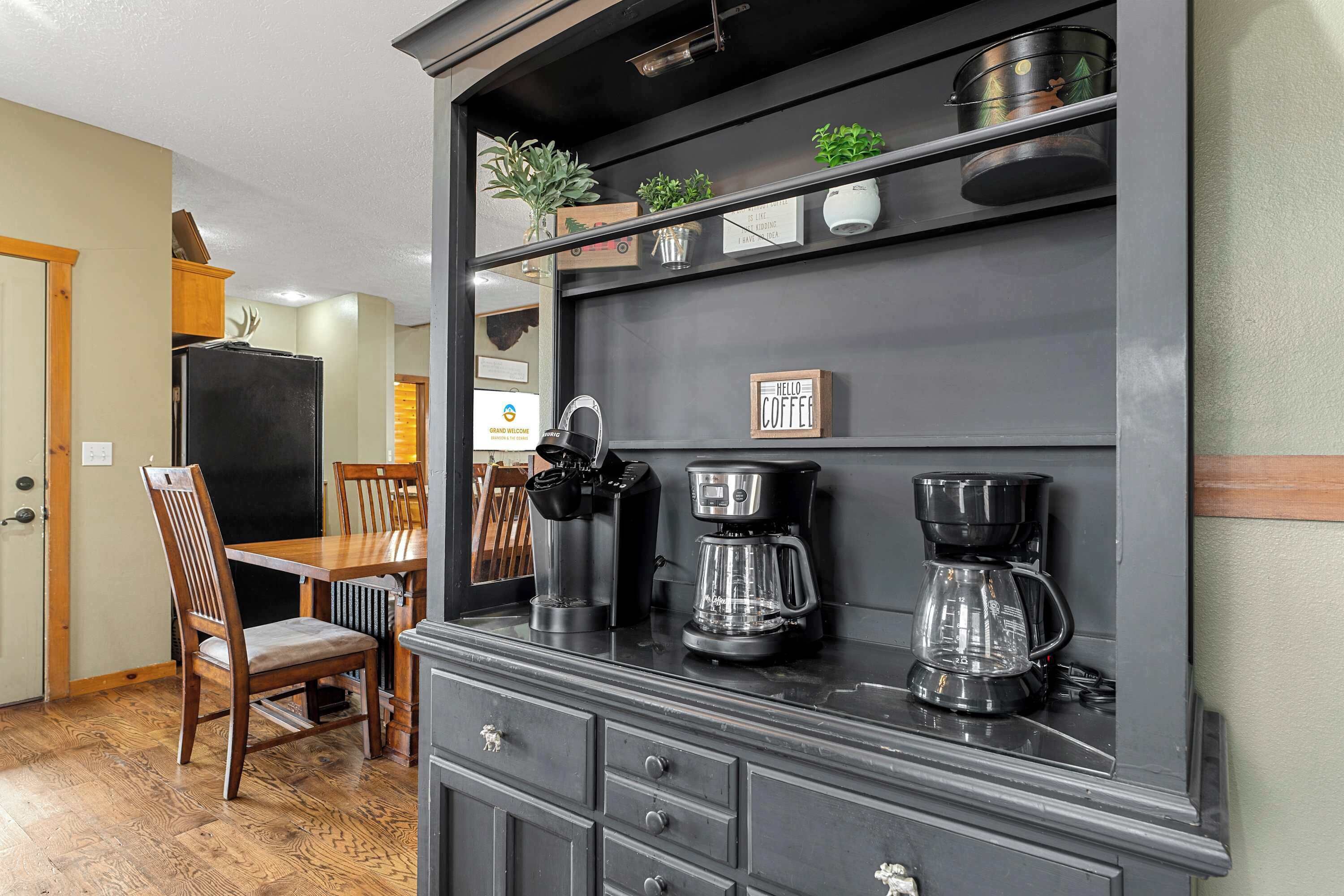 A kitchen with a dark wooden cabinet, a coffee maker, and a refrigerator.
