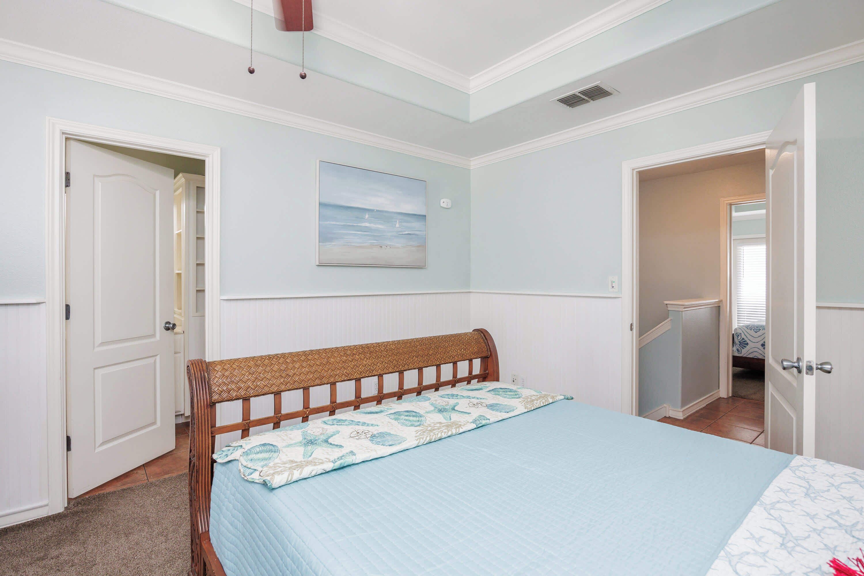 A bedroom with a bed, a door, and a hallway.