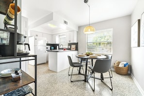 Enjoy meals in the kitchen with a central island and dining area featuring a round table and chairs.