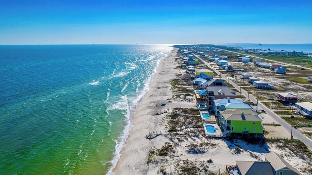 An aerial view of a coastal area with beach houses, a swimming pool, and a clear view of the ocean. - A Wave From it All - 3BR Beachside Coastal Retreat (Gulf Shores)