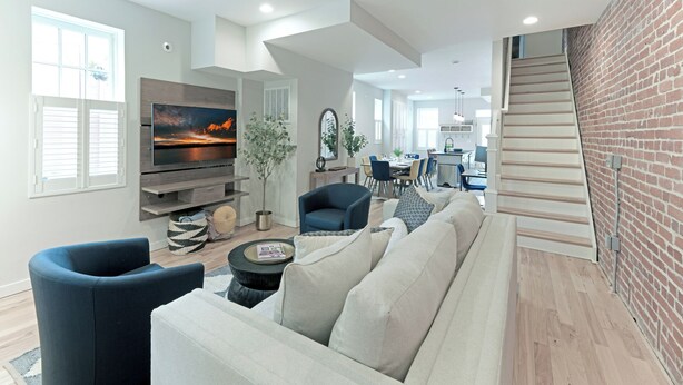 A modern living room with a flat-screen TV, a sofa, and a dining area in the background. - Upscale Old Town Alexandria Retreat - Walk to King St Metro (Alexandria)