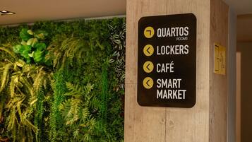 A sign with directions to rooms, lockers, cafe, and smart market.
