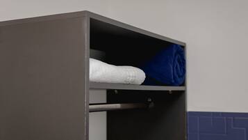 Un armario gris con una toalla blanca y una azul en su interior.