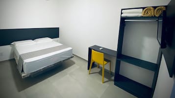 A room with a bed, a desk, a bunk bed, and an air conditioning unit.