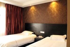 A hotel room with two beds, a dark headboard, a telephone, and a patterned wall. - Hengdian Kaiman Hotel (Dongyang)