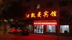 A hotel with a prominent neon sign in yellow. - Hengdian Kaiman Hotel (Dongyang)