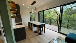 Eine moderne Küche mit Essbereich, großen Fenstern und einem Balkon.