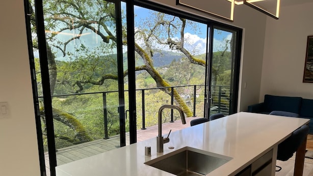 Eine moderne Küche mit einem großen Fenster mit Blick auf eine üppige Landschaft.