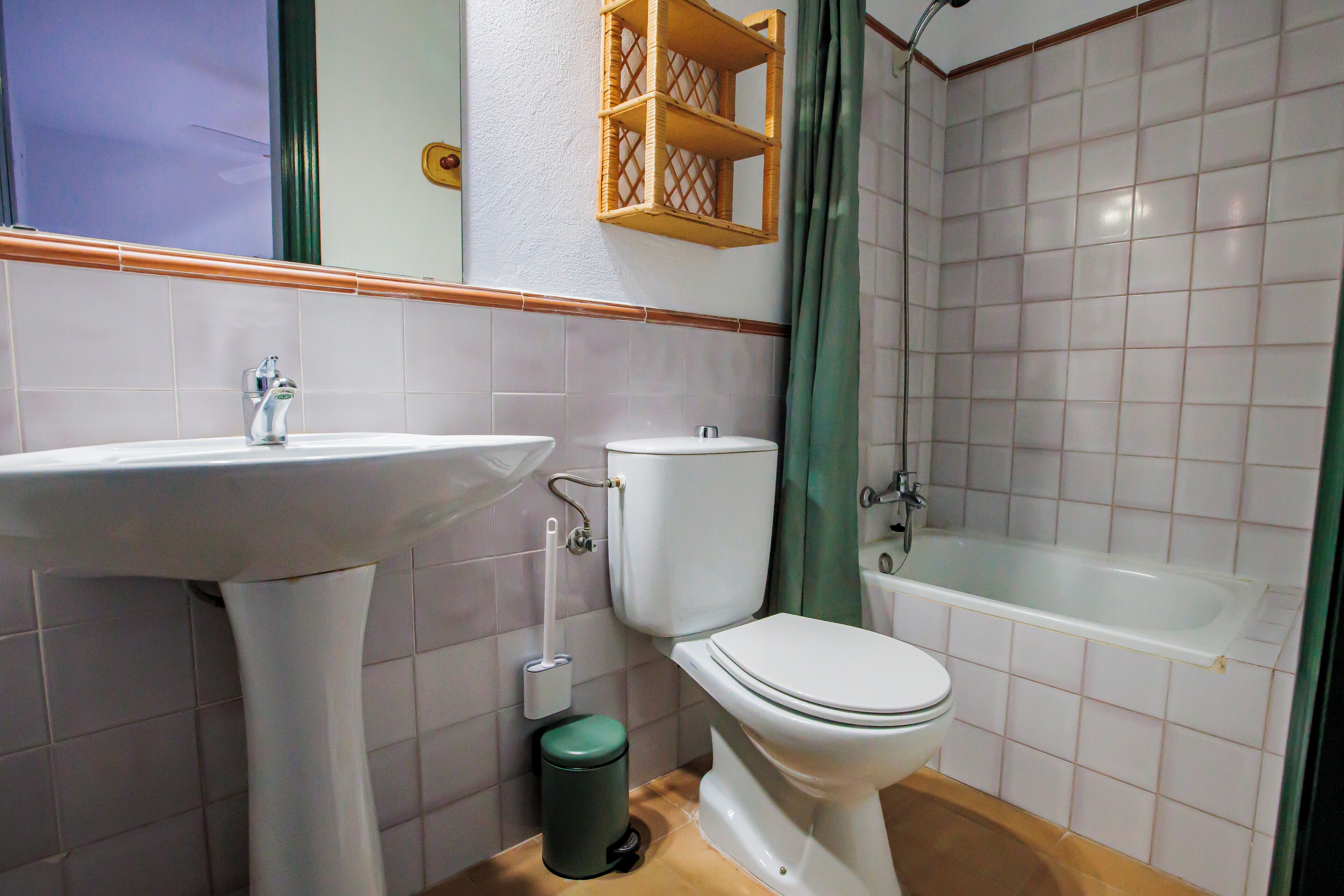 Un baño con lavamanos, inodoro y bañera.