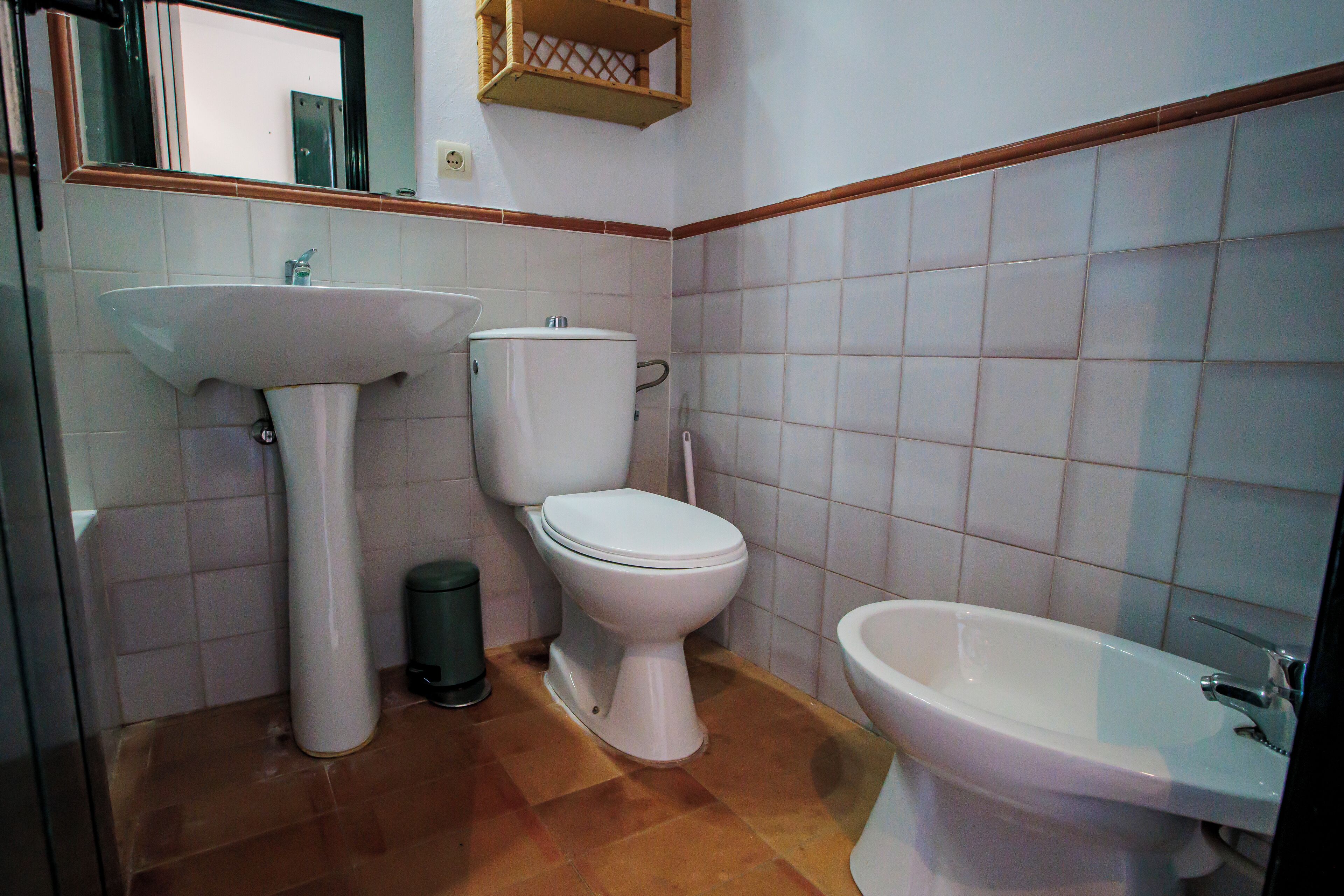 Un baño con lavamanos, inodoro y bidé.