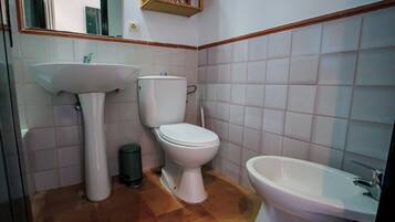 Un baño con lavamanos, inodoro y bidé.