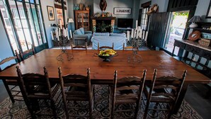 A dining room with a large wooden table, six chairs, and a bowl of fruit. - HN Romero 18 (Almonte)