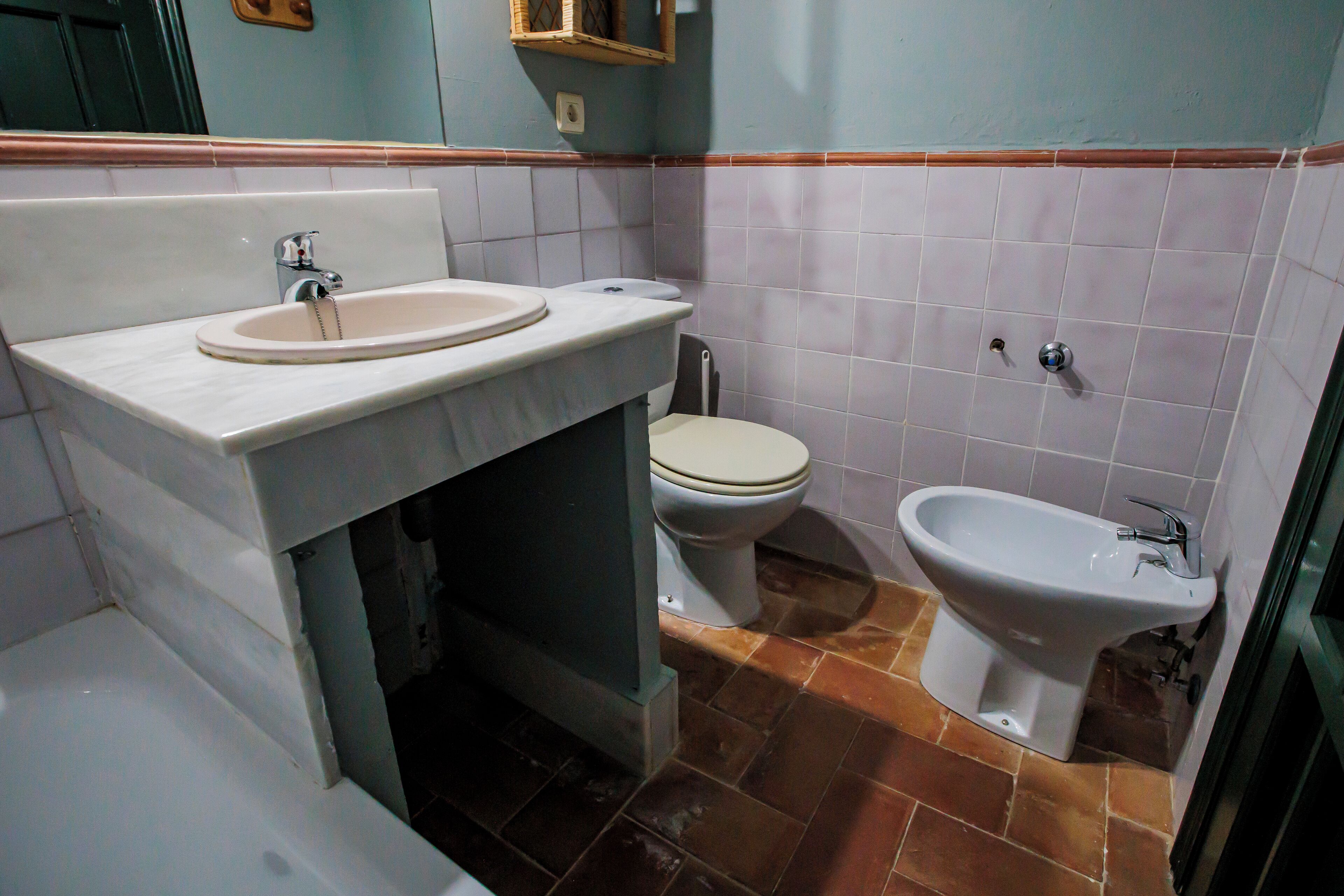 Un baño con lavamanos, inodoro y bidé.