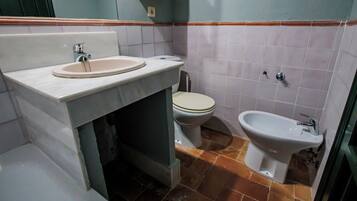 Un baño con lavamanos, inodoro y bidé.