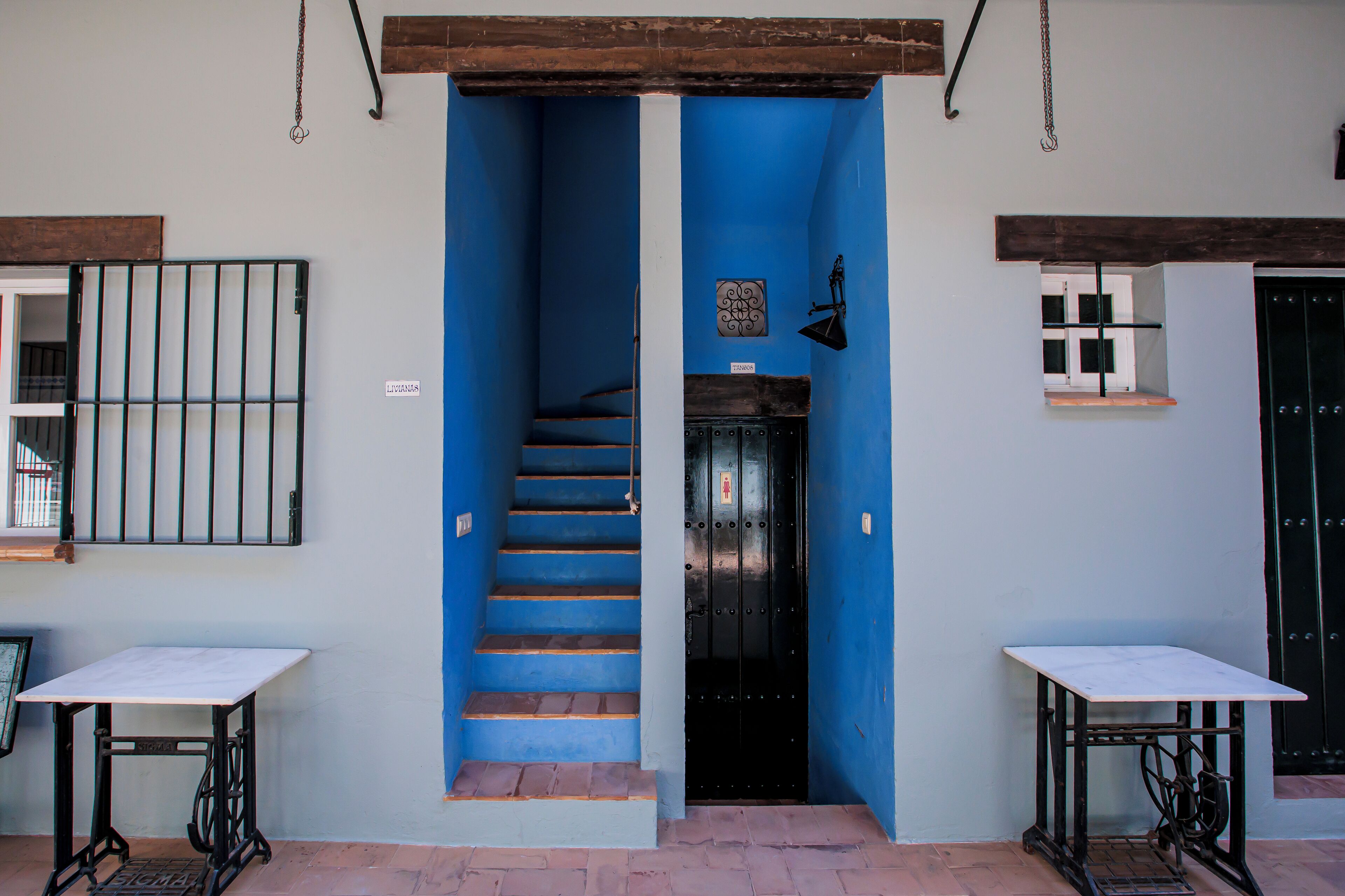 A staircase leading to a door, with a table on each side.