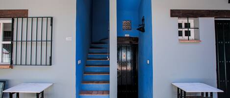 A staircase leading to a door, with a table on each side.