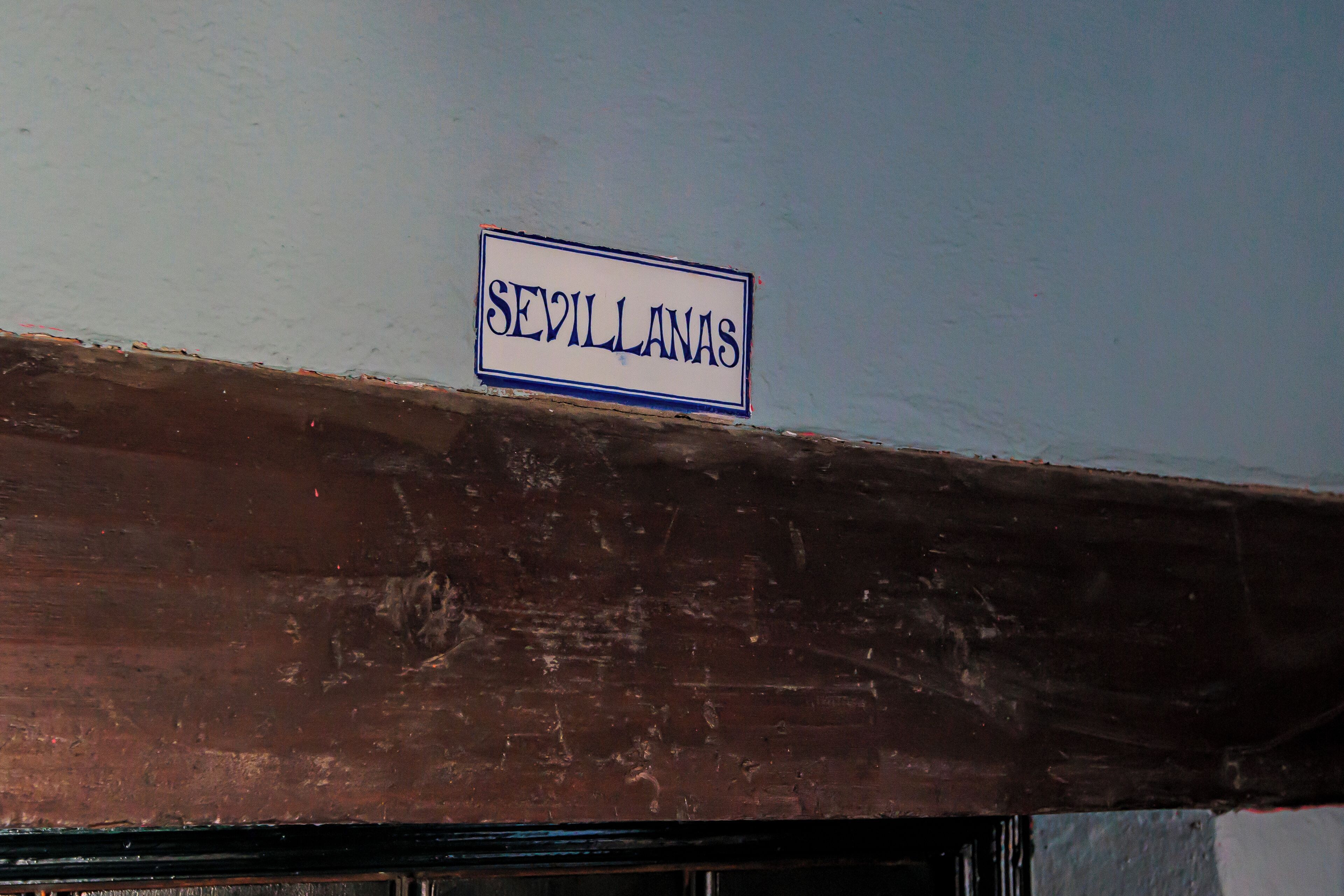Un letrero con el nombre "SEVILLANAS" en la fachada de un edificio.