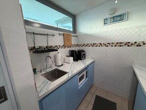 A compact kitchen with a sink, a coffee maker, and a microwave. - One minute walk to the beach! (Luquillo)