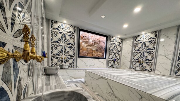 A luxurious bathroom with a marble vanity, a freestanding bathtub, and intricate wall designs. - Çelik Thermal & Spa (Denizli)