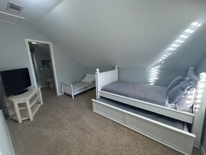 A bedroom with a bunk bed, a television on a stand, and a door leading to another room. - Huge property with Lake Access! 8 separate sleeping spaces, 4 baths! (Kingsland)