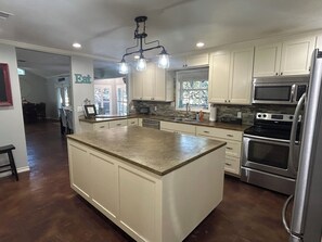 A kitchen with a large island, stainless steel appliances, and a view to the outside. - Huge property with Lake Access! 8 separate sleeping spaces, 4 baths! (Kingsland)
