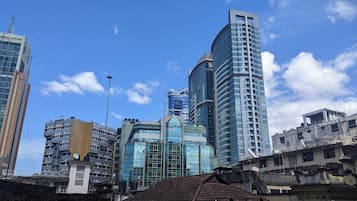 Un paysage urbain avec des immeubles modernes de grande hauteur, dont un gratte-ciel remarquable qui se distingue par son design original au sommet.