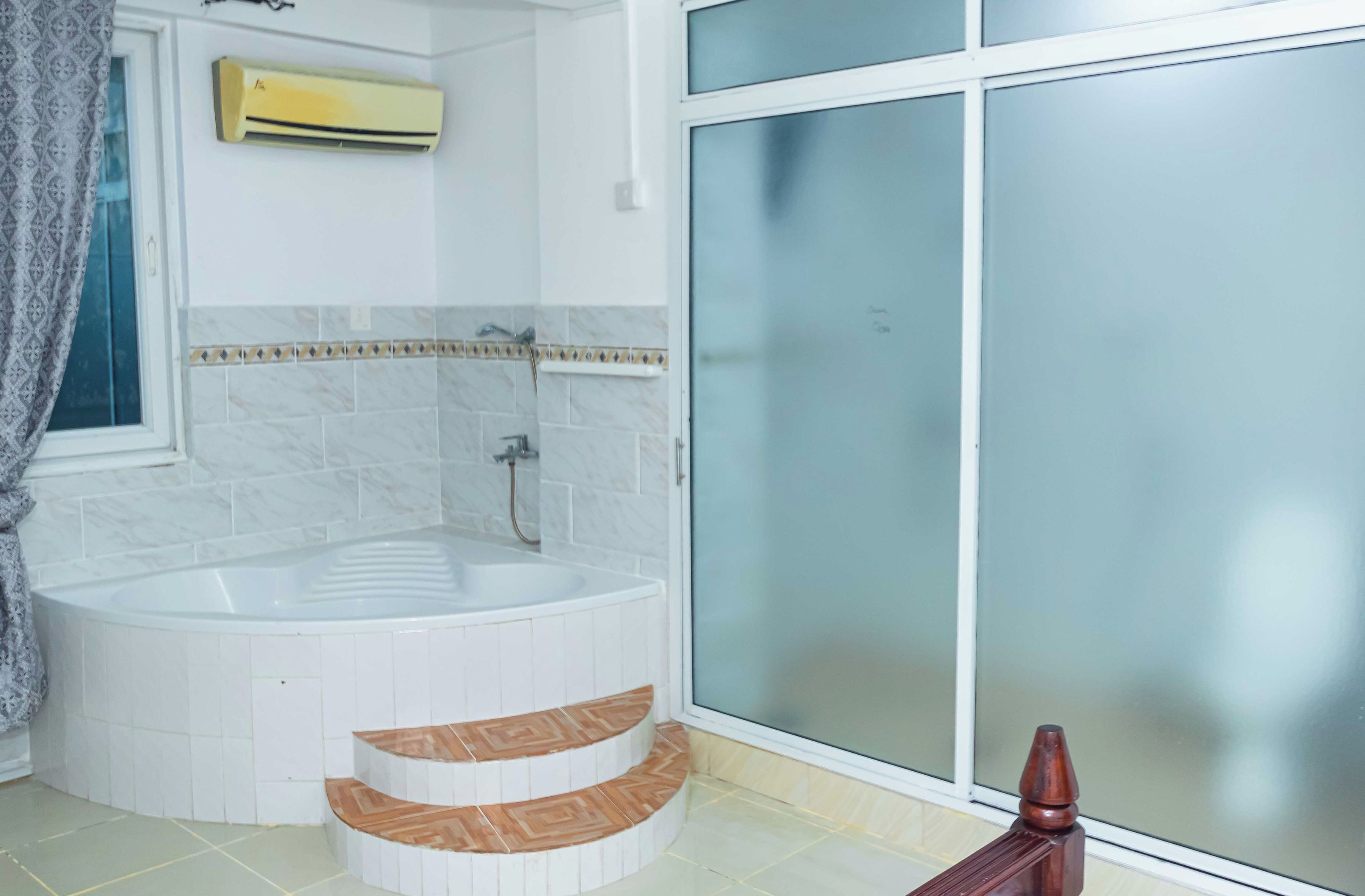 A bathroom with a freestanding bathtub, a shower, and a glass door leading to a balcony.