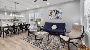 A modern living room with a dining area, a ceiling fan, and a large abstract painting on the wall. - Retreat to a Brand-new Downtown Home 4BR 3BA (San Antonio)